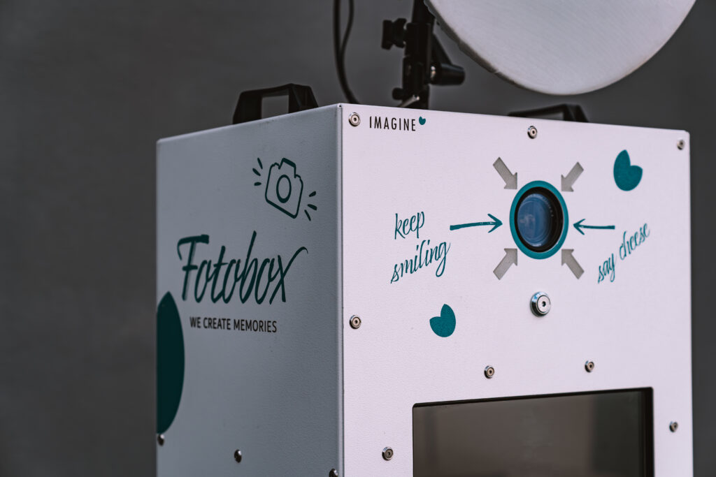 Freunde posieren mit Requisiten vor der Imagine Fotobox
